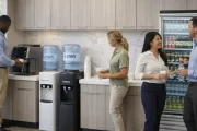 Fitness center members filling bottles at a water dispenser